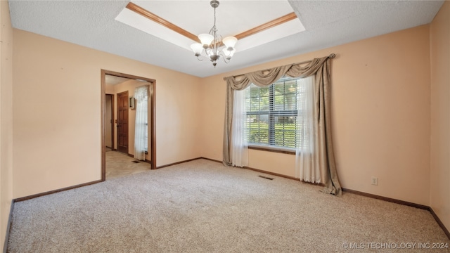 carpeted empty room featuring a chandelier and a textured ceiling