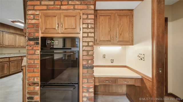 kitchen featuring double oven, a textured ceiling, and wood walls