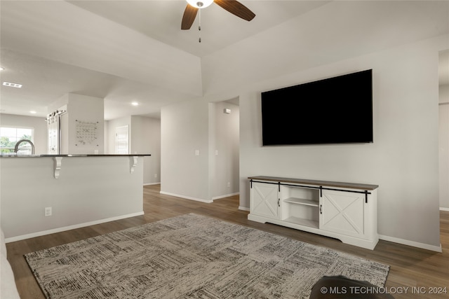 unfurnished living room featuring ceiling fan and dark hardwood / wood-style flooring