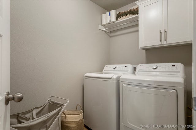 washroom with cabinets and washing machine and clothes dryer