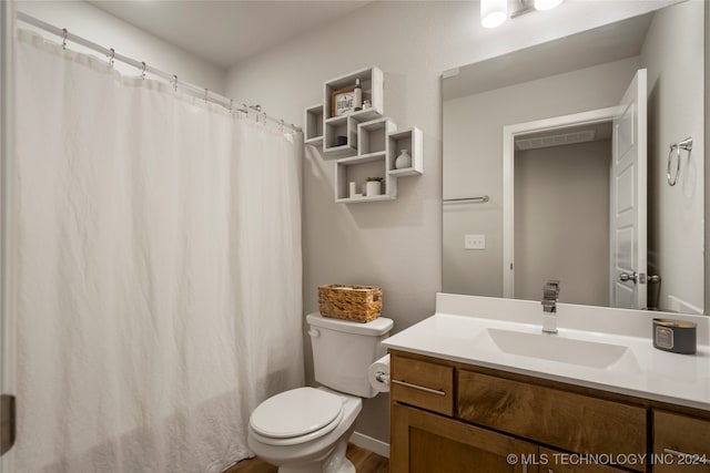 bathroom with wood-type flooring, vanity, and toilet