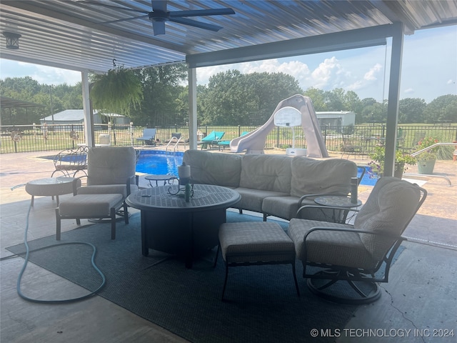 view of patio with an outdoor living space, a fenced in pool, and ceiling fan