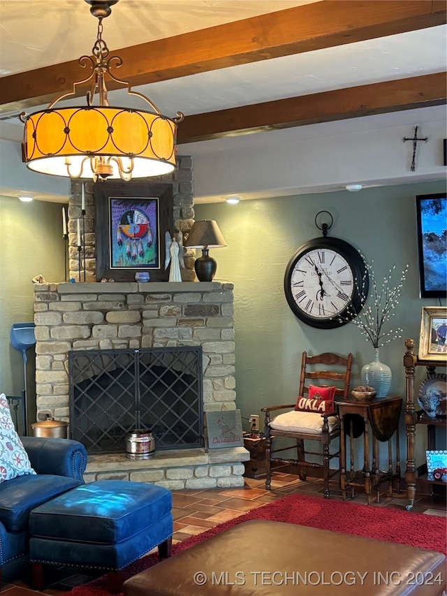 living room with beamed ceiling and a stone fireplace