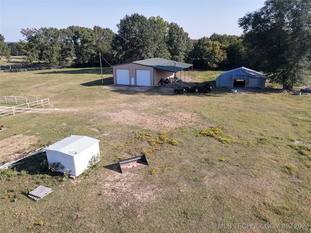 view of yard with an outbuilding, a garage, and a rural view