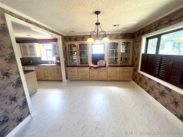 unfurnished dining area with a wealth of natural light, a chandelier, a textured ceiling, and ornamental molding