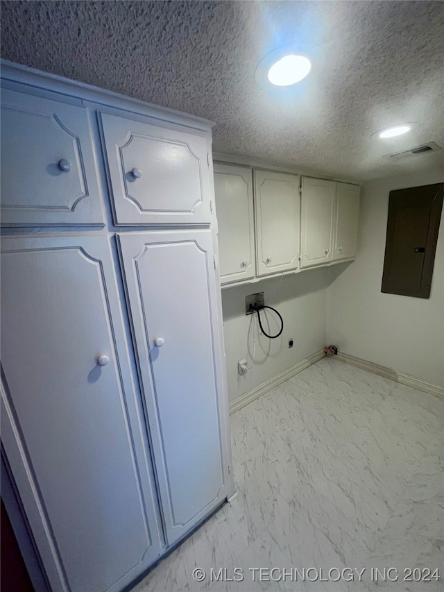 kitchen with white cabinets, electric panel, and a textured ceiling