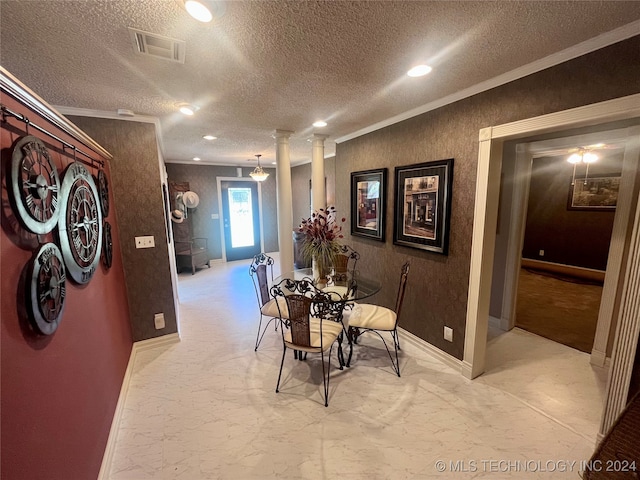 dining area featuring a textured ceiling, light colored carpet, ornamental molding, and ornate columns