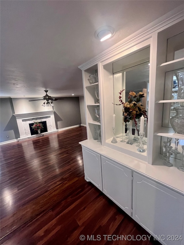 bar with built in features, ceiling fan, dark hardwood / wood-style floors, and white cabinetry