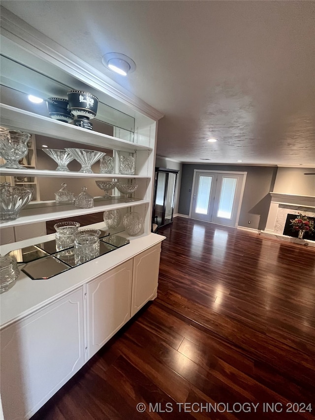 bar with a fireplace, french doors, wood-type flooring, and white cabinets