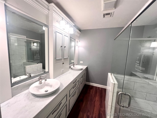 bathroom with vanity, a shower with shower door, and wood-type flooring