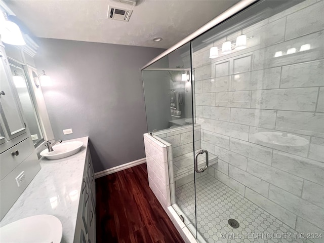 bathroom featuring vanity, toilet, wood-type flooring, and a shower with door