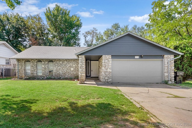 single story home featuring a garage and a front lawn