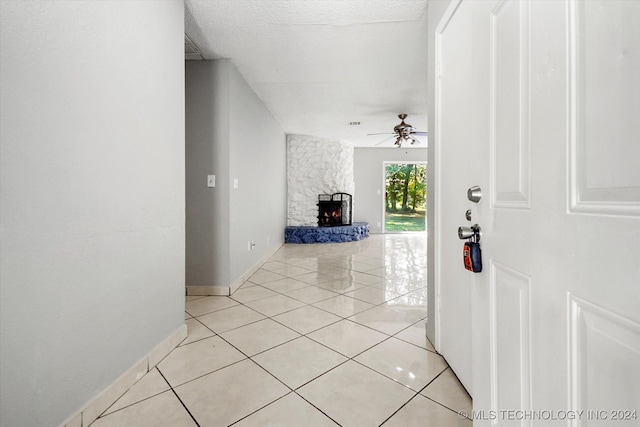 corridor featuring light tile patterned flooring and a textured ceiling