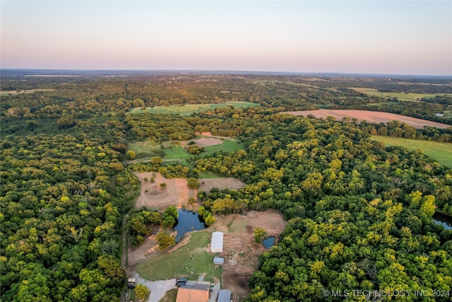 aerial view at dusk featuring a water view