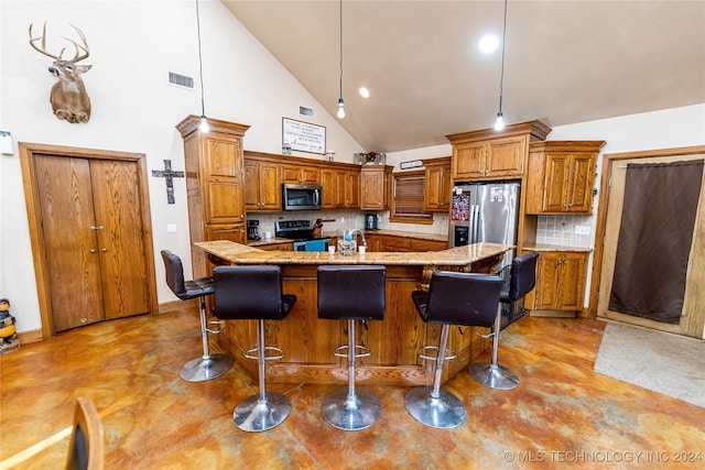 kitchen featuring stainless steel appliances, high vaulted ceiling, a kitchen island with sink, and a kitchen bar