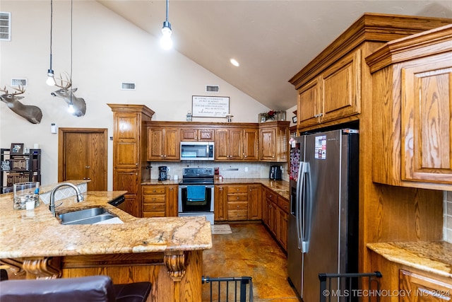 kitchen with decorative light fixtures, appliances with stainless steel finishes, sink, and a kitchen breakfast bar