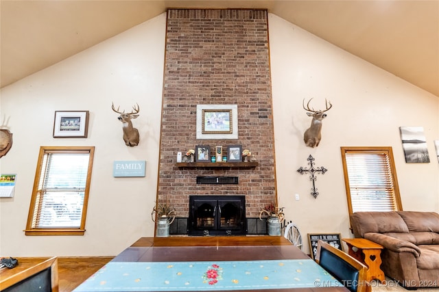 living room featuring lofted ceiling, wood-type flooring, and a fireplace