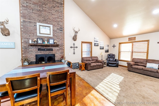 living room featuring high vaulted ceiling, a fireplace, and carpet floors