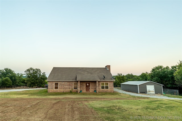 view of front of property with an outdoor structure, a garage, and a lawn