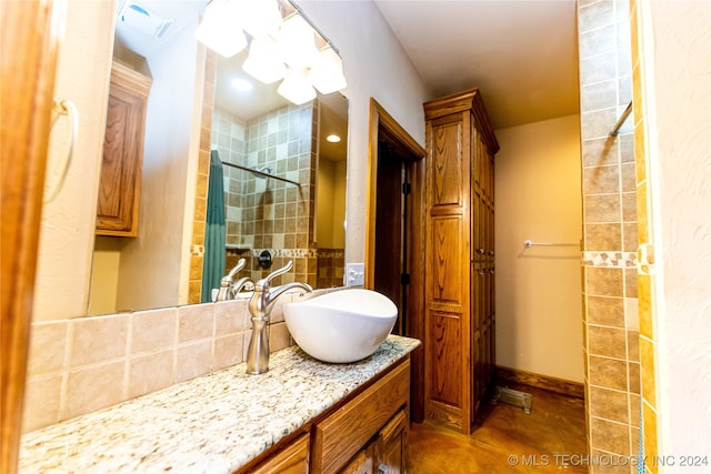 bathroom featuring a tile shower and vanity