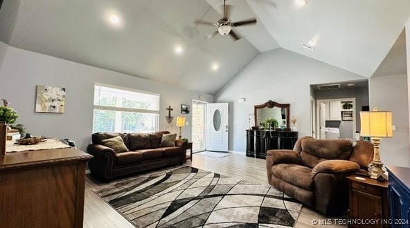 living room featuring high vaulted ceiling, light wood-type flooring, and ceiling fan