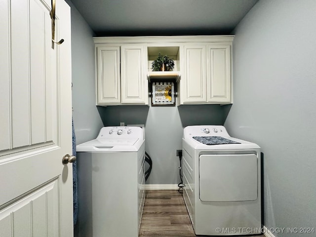 clothes washing area with cabinets, dark hardwood / wood-style floors, and separate washer and dryer