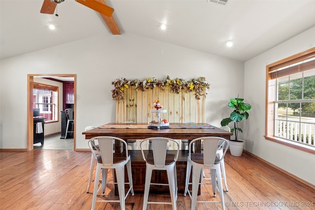 tiled dining area featuring ceiling fan, a wealth of natural light, and vaulted ceiling with beams