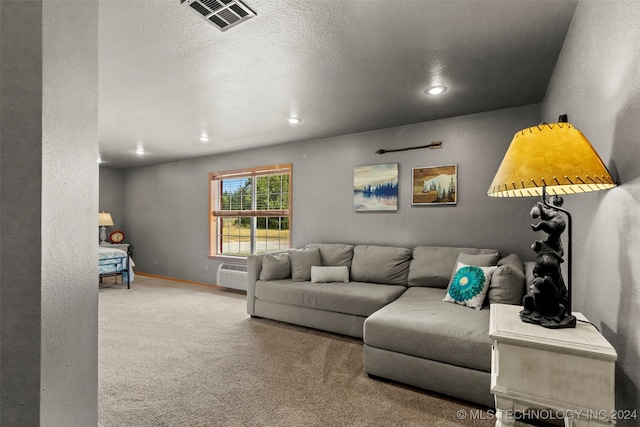 living room featuring a wall unit AC, carpet, and a textured ceiling