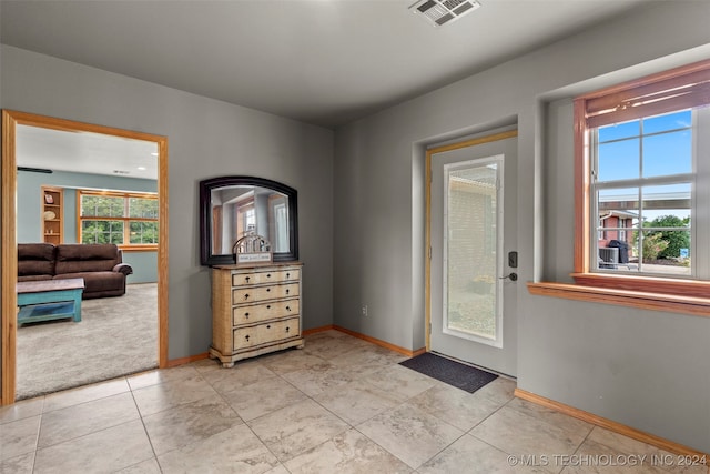 doorway to outside with light tile patterned floors