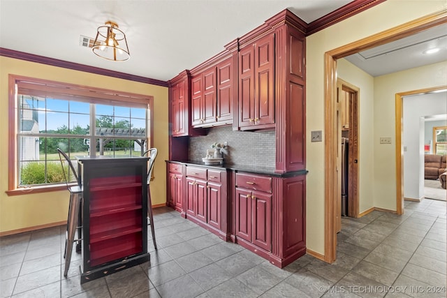 kitchen with backsplash, crown molding, and tile patterned flooring