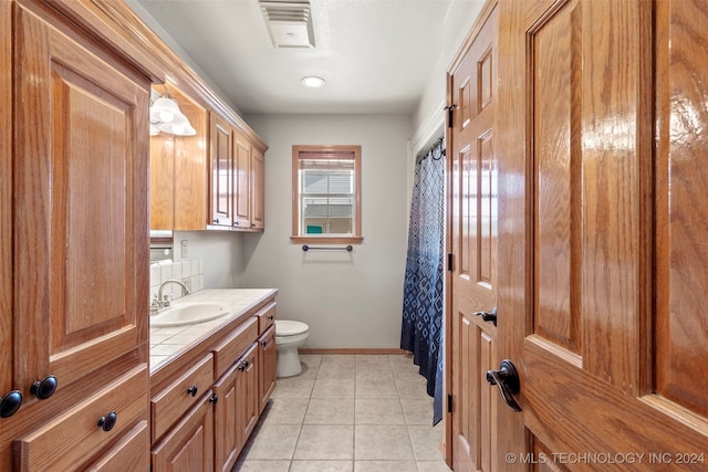 bathroom with vanity, toilet, and tile patterned floors