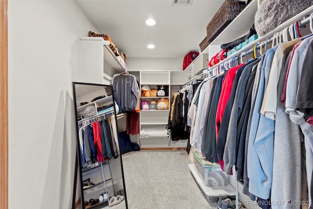 walk in closet featuring light colored carpet