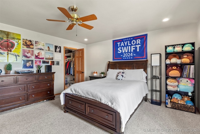 bedroom featuring a closet, ceiling fan, a spacious closet, and light carpet