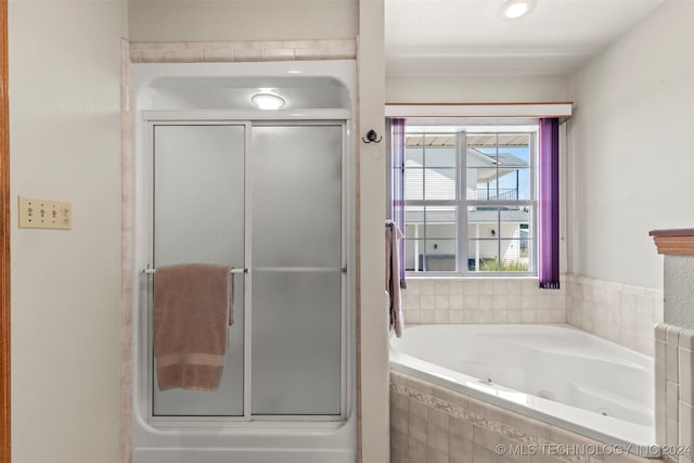 bathroom featuring shower with separate bathtub and radiator