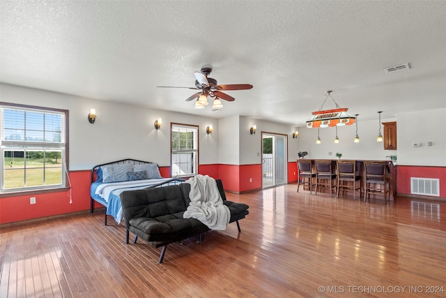 bedroom with a textured ceiling and hardwood / wood-style flooring