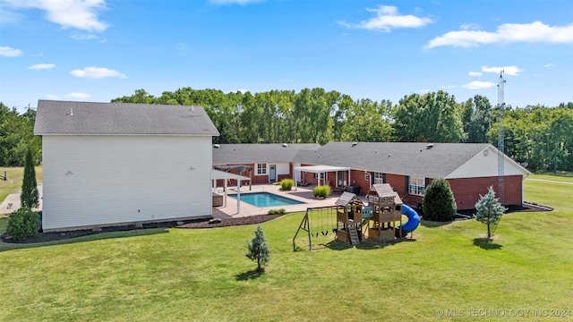 rear view of property with a playground and a lawn