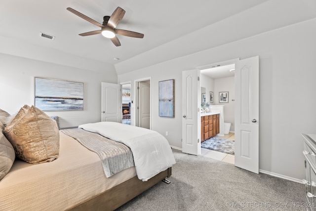 bedroom featuring ensuite bath, light carpet, and ceiling fan