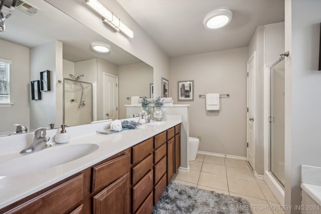 bathroom featuring tile patterned flooring, vanity, toilet, and walk in shower