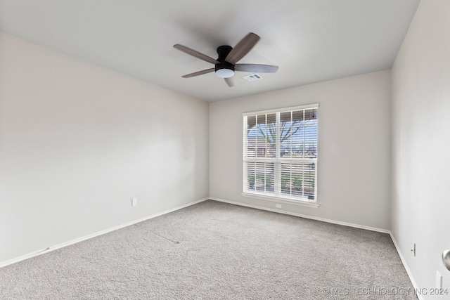 carpeted spare room with ceiling fan