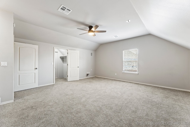 interior space with ceiling fan, light colored carpet, and vaulted ceiling