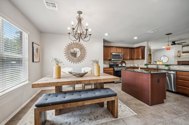 kitchen featuring kitchen peninsula, decorative backsplash, stainless steel appliances, and hanging light fixtures