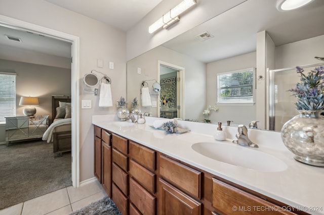 bathroom with tile patterned flooring, vanity, and walk in shower