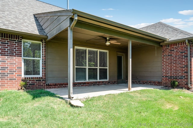 doorway to property featuring ceiling fan and a yard