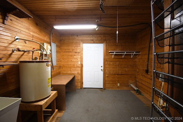 basement featuring carpet flooring, wood walls, wooden ceiling, and water heater