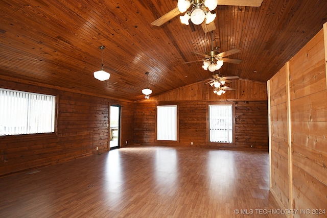 empty room featuring ceiling fan, wood walls, wood-type flooring, vaulted ceiling, and wood ceiling