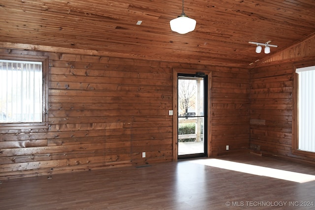 unfurnished room featuring wood ceiling, dark wood-type flooring, a healthy amount of sunlight, and lofted ceiling