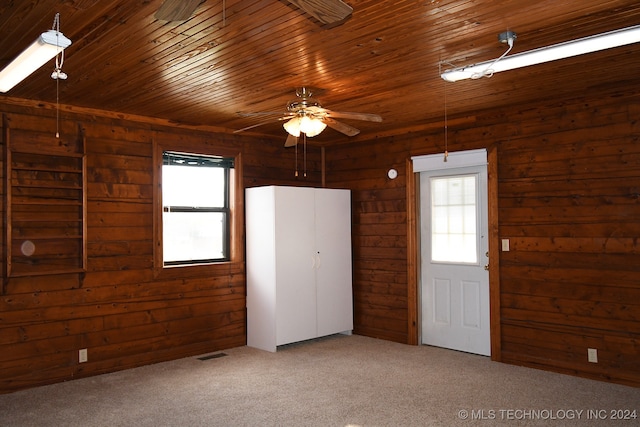 unfurnished room with carpet flooring and wood walls