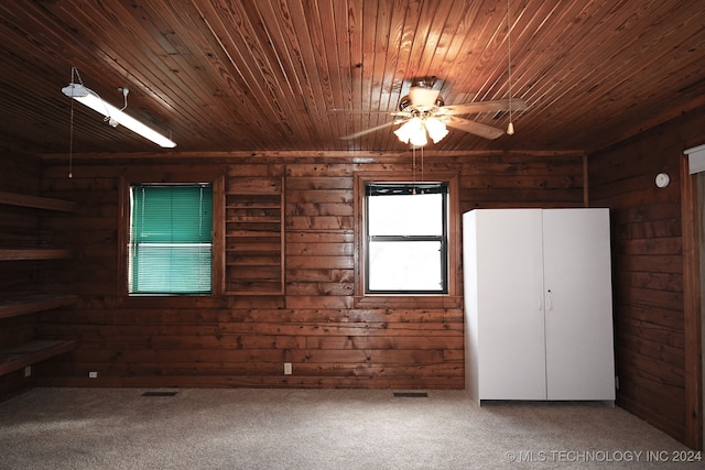 unfurnished bedroom with carpet, wooden walls, and wood ceiling