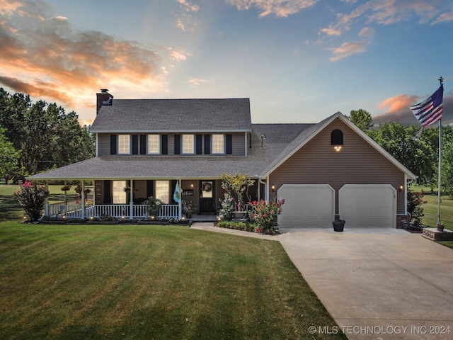 view of front facade with a yard, a garage, and a porch