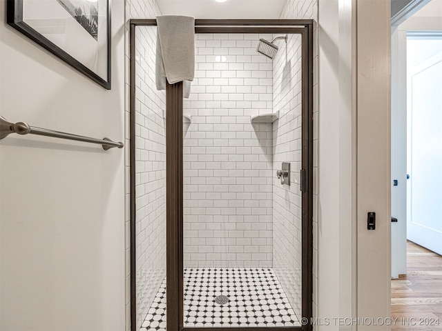 bathroom featuring hardwood / wood-style flooring and a shower with door